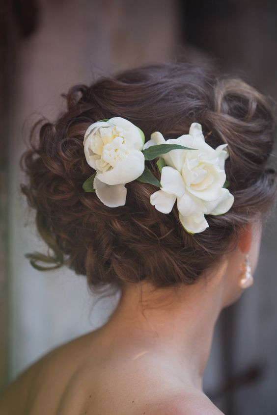 curled and braided updo with gardenia flowers