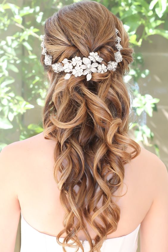 curled half updo with a headpiece