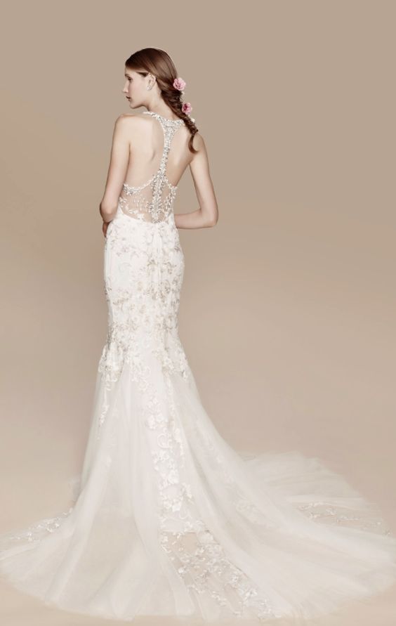 A bride wearing a lace mermaid wedding dress with a train and a sparkling bead racerback.