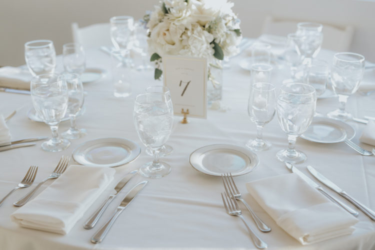 Einfache und elegante Tisch-Dekor mit weißen Blumen, Geschirr und Stoffe