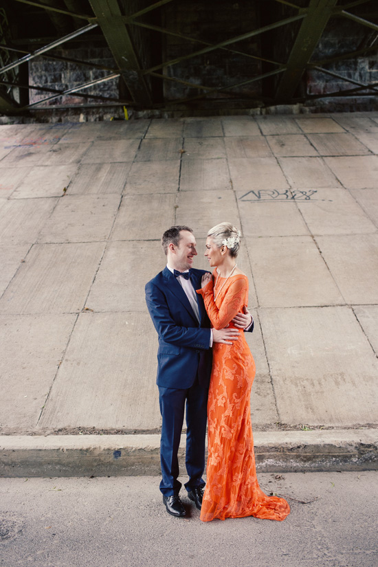 die Braut rocking einem kräftigen orange-Spitze-Hochzeits-Kleid mit langen ärmeln und eine Perlenkette