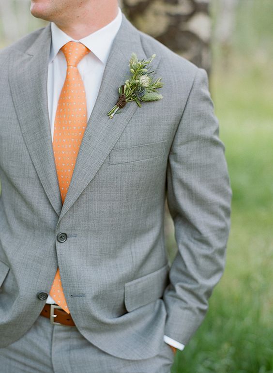 in einem grauen Anzug, einem weißen shirt und einer gedruckten orange Krawatte für einen eleganten look mit einem bunten touch