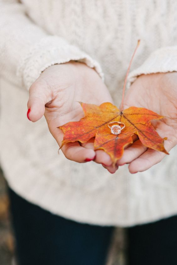 zeigen Sie Ihre Verlobungsring auf einen bunten Herbst-Blatt