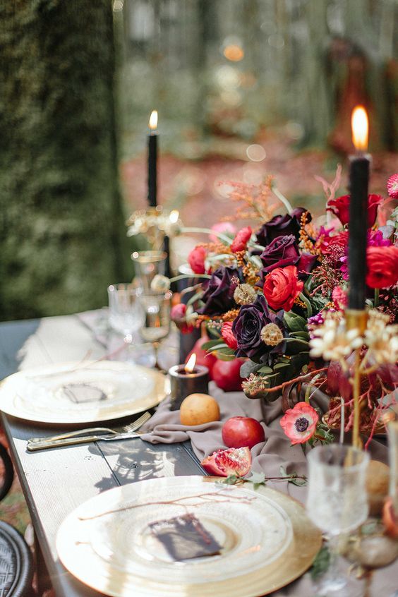 eine raffinierte moody ' wedidng tablescape mit dunklen Blumen, Granatäpfel und vergoldete Ladegeräte
