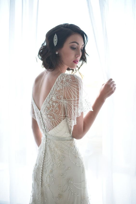 eine bestickte und mit Perlen Hochzeit Kleid mit einem V-Ausschnitt auf der Rückseite, eine Reihe von buttons und flowy ärmel
