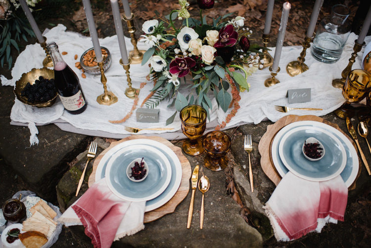 Picknick-tablescape fertig war mit blauen Geschirr, ombre rosa Servietten, Grau, Kerzen, Bernstein und gold-details