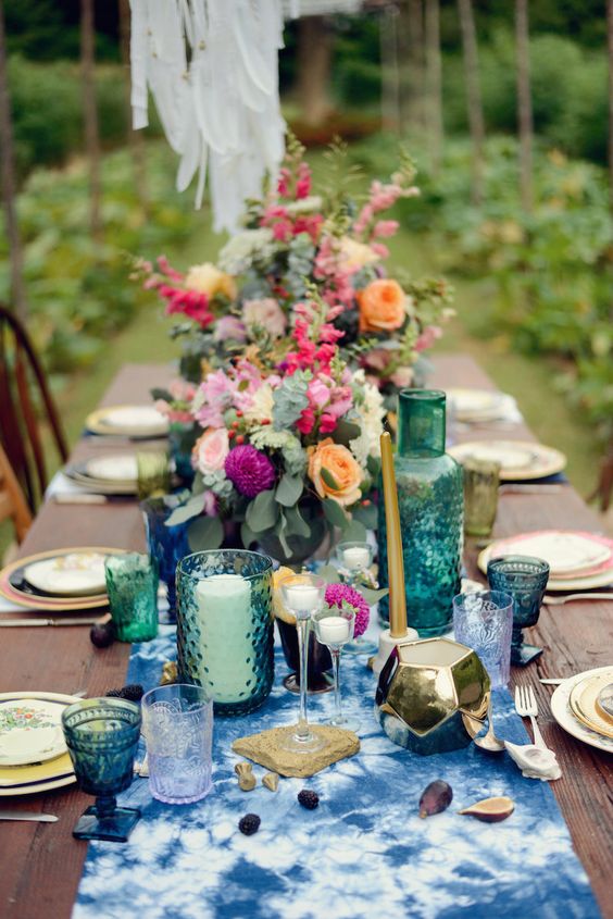 eine boho tablescape mit indigo gefärbt Tischläufer, Smaragd und indigo-Brille und Fett florals