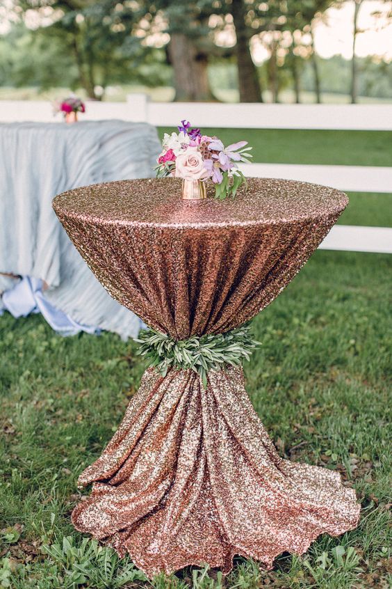ein Kupfer Pailletten Tischdecke für eine Hochzeit, lounge, dekoriert mit viel grün und einem kleinen Blumen-Mittelstück