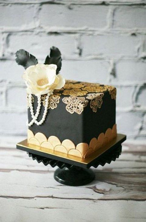 eine quadratische mini-Kuchen in schwarz und gold, mit Jakobsmuscheln, Spitze, Blumen, Perlen, Zucker Blume und schwarzen Federn