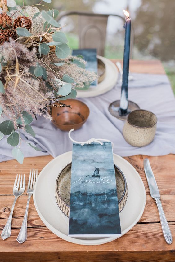 eine Hochzeit tablescape mit indigo Platzkarten, Kerzen und eine hellblaue Tischläufer