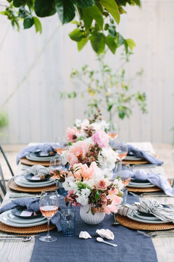 ein wedidng tablescape mit einer indigo Tischläufer, Gläser und Servietten und rosa Blumen