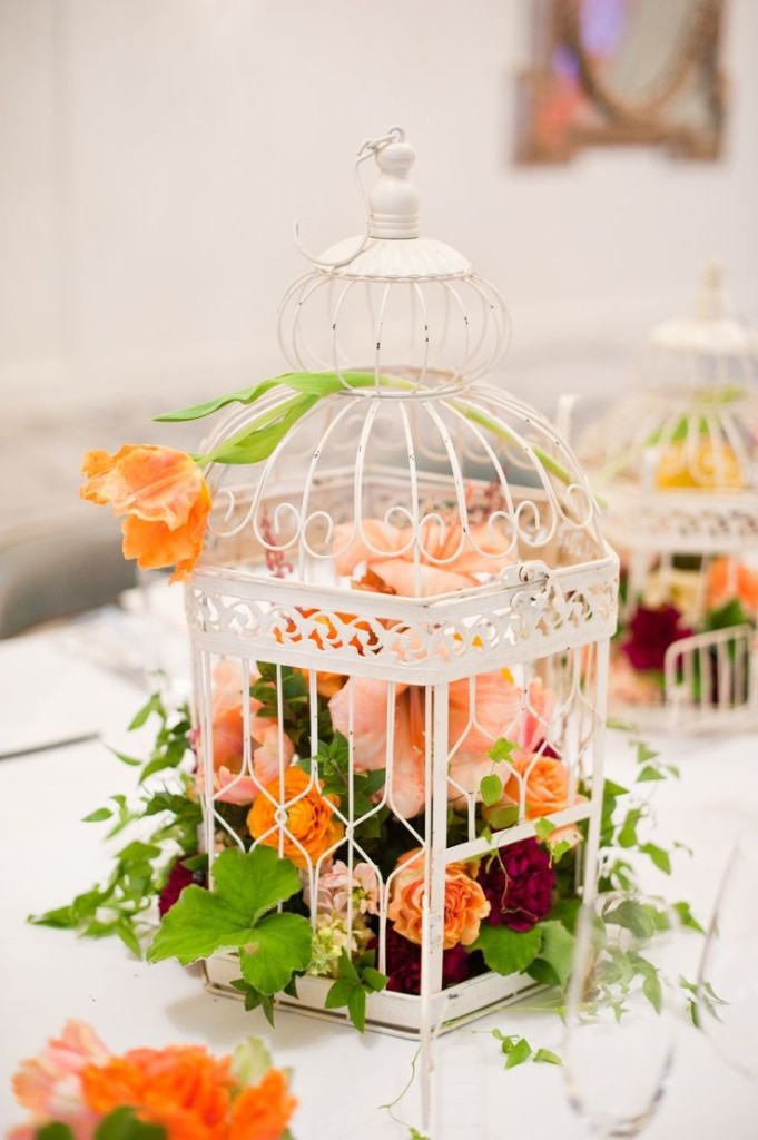 ein weißer Käfig mit üppigen orange, peachy und Burgund Blüten für eine mutige, Hochzeit