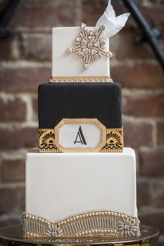 eine wunderschöne schwarze und weiße Quadrat-Kuchen mit gold geo-Dekor, vintage-Broschen und Perlen und Federn