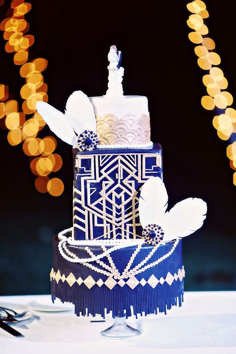 eine Kobalt-Blaue und weiße Hochzeitstorte mit Rosen-Muscheln, Perlen, Federn und vintage-Broschen