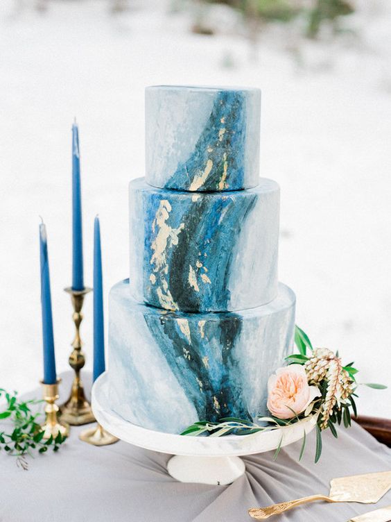 eine indigo-und gold-Blatt-Hochzeits-Kuchen und indigo Kerzen für einen Akzent