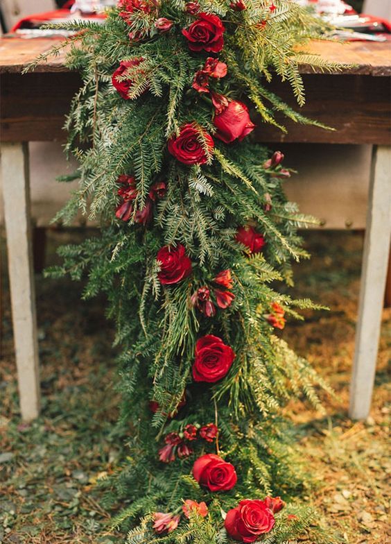 ein evergreen Tischläufer mit roten Rosen ist eine schicke und gewagte Idee für jede winter großen Tag