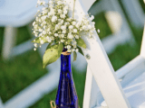 a blue wine bottle with baby’s breath is a beautiful wedding aisle decoration to rock, and you can eaisly make one yourself