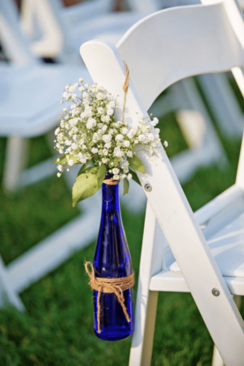 a blue wine bottle with baby's breath is a beautiful wedding aisle decoration to rock, and you can eaisly make one yourself