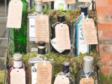 a stand with moss and various bottles of alcohol and with escort cards is a very creative idea to rock