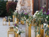 a beautiful wedding entrance decorated with gold bottles with bold blooms and matching gold candle lanterns is a lovely idea to rock