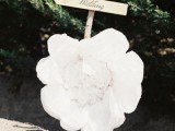 an oversized white flower with a sign is a catchy and cool decor idea for a modern wedding