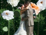 a pretty and catchy wedding ceremony space with oversized white and yellow blooms of paper for an eco-friendly wedding