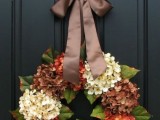 a bright vintage fall wreath with fresh white and rust hydrangeas and brown dired ones, with leaves and an elegant brown ribbon bow is wow