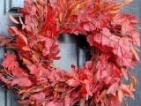 a bright fall wreath of yellow and fiery red leaves plus twigs is a very cool fall decor idea