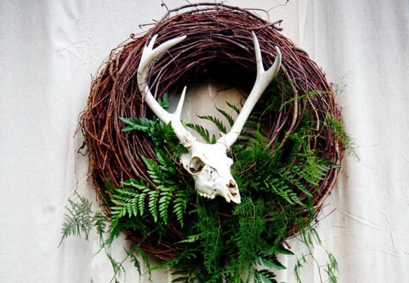 A fall woodland wreath of vine, with lots of ferns and an animal skull is a mystical idea suitable also for a Halloween wedding