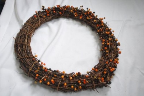 a vine fall wreath with berries integrated is a bright and cool idea for a rustic fall wedding