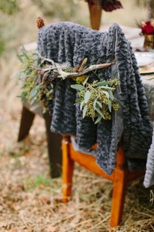 a grey faux fur cover with greenery and sticks is a chic and cozy alternative to a usual chair cover