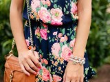 a navy romper with a bright floral print and an amber bag for a casual summer bridal shower