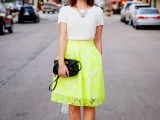 a simple look with a trendy neon green skirt with pockets, a white t-shirt, a statement necklace, black shoes and a clutch