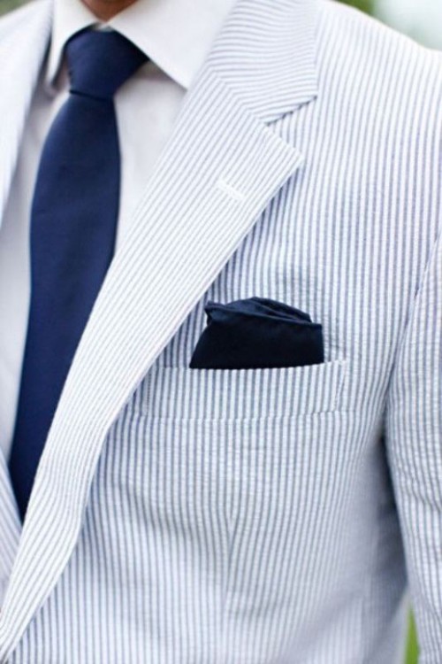 a light blue thin stripe suit, a white shirt and a navy tie are a great look for a coastal groom