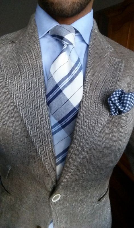a grey checked suit, a white shirt, a striped tie for a casual and less formal groom's look