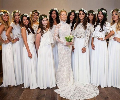 dreamy bridesmaids looks done with mismatching white sleeveless lace crop tops and matching pleated white skirts with trains for a trendy all-white bridesmaid look