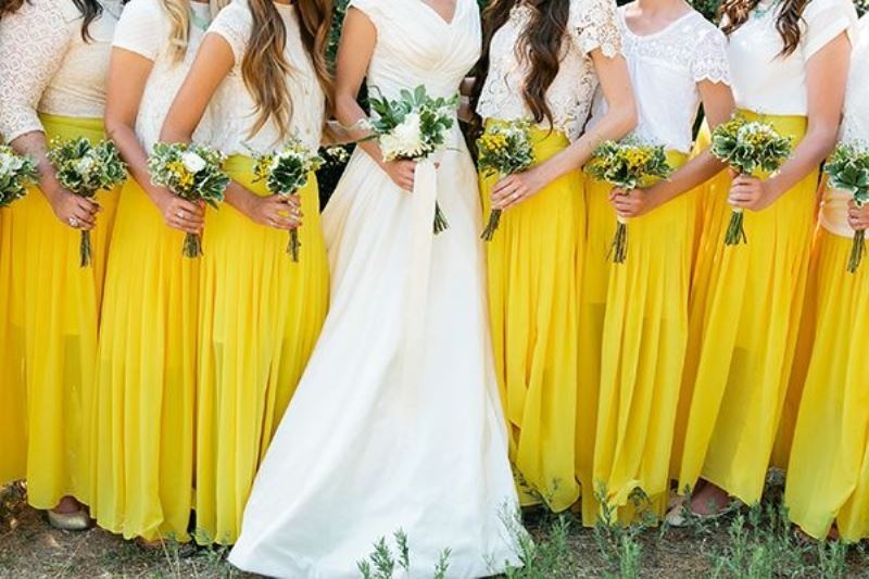 Mismatching white plain and lace tops with short sleeves and neon yellow maxi skirts for a bright spring or summer wedding
