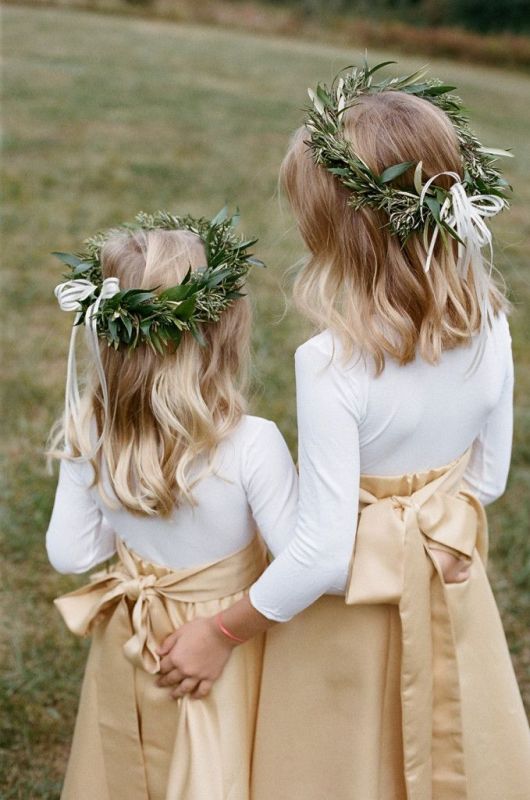 White long sleeve tops, tan A line maxi skirts, greenery crowns with bows for modern and stylish inter flower irls