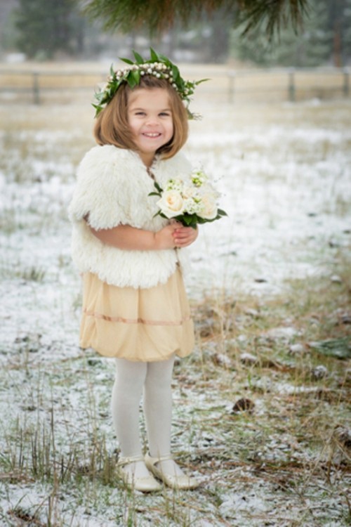 a short tan dress, a white faux fur coverup, white tights and shoes for a chic and beautiful winter flower girl look