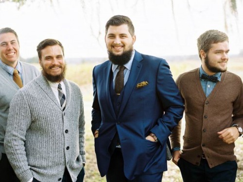 groomsmen wearing white and grey shirts, bow ties and ties and mismatching cardigans for a casual and stylish look