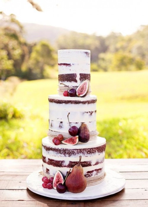 a naked chocolate wedding cake topped with cherries, grapes and pears is a stylish idea for a summer wedding or a fall one