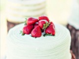 a light green textural buttercream wedding cake topped with strawberries is a cool idea for a summer wedding
