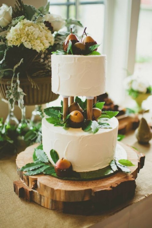 two white textural wedding cakes topped with greenery and with chocolate dipped pears is a gorgeous and delicious idea for a summer or fall wedding