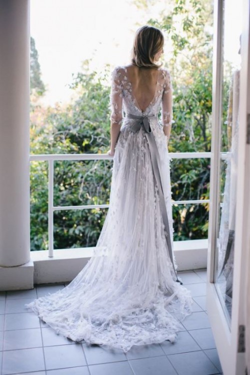 a chic and girlish A-line wedding dress with short sleeves, a cutout back, floral appliques and a sash is a lovely idea for a spring or summer bride