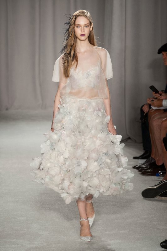 A unique wedding dress with a sheer bodice and a floral petal midi skirt, lace up shoes is a fashion forward idea