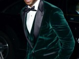 a chic fall or winter groom’s outfit with a green velvet blazer with black lapels, a waistcoat, a black bow tie and pants