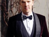 Benedict Cumberbatch wearing a burgundy velvet tuxedo with printed black lapels, a black waistcoat and a printed bow tie