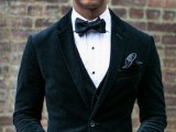 a stylish groom’s outfit with a three-piece dark green velvet suit and a black bow tie plus a black silk bow tie