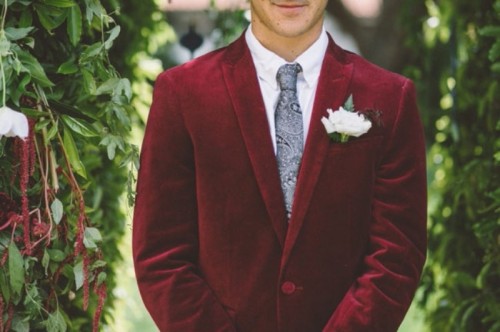 a burgundy velvet blazer with a grey printed tie is a stylish combo for a fall or winter groom's look
