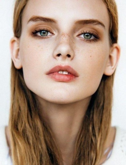 a nude-style makeup with a matte pink lip, brown smokeys, fresh and shiny skin and accented green eyes